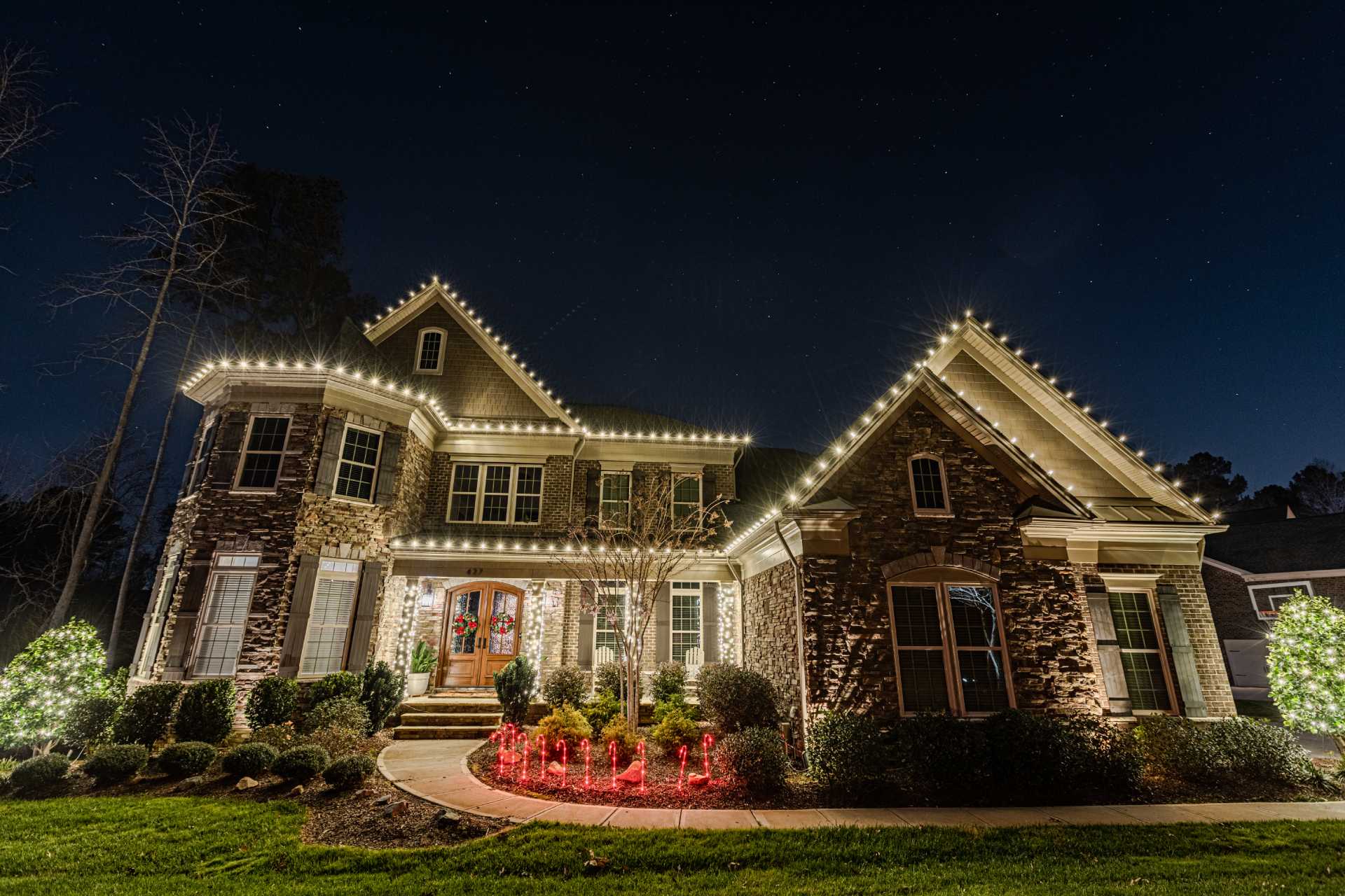 Professional Christmas light installation highlighting a home and landscaping